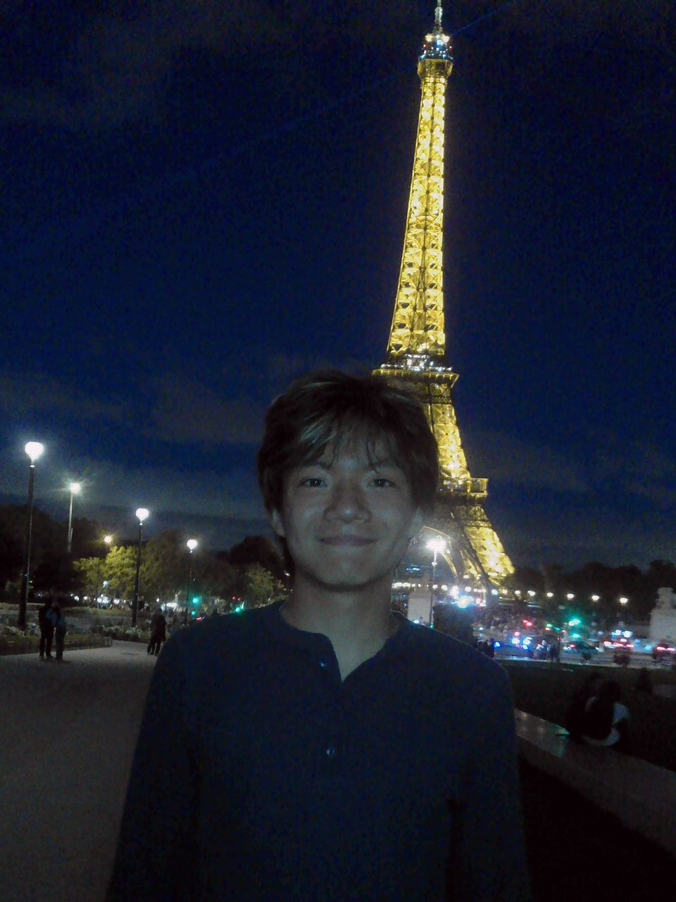 Jerry Ma in front of the Eiffel Tower at night